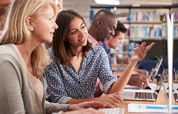 A group of students working on their computers in a quiet setting.