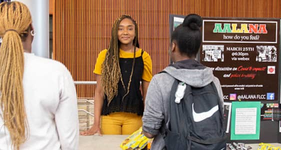 Students registering for a club during a tabling event in the FLCC main lobby.