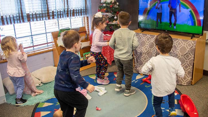 A group of children dancing along to a show.