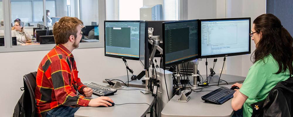 Students in computer lab using dual screen monitors