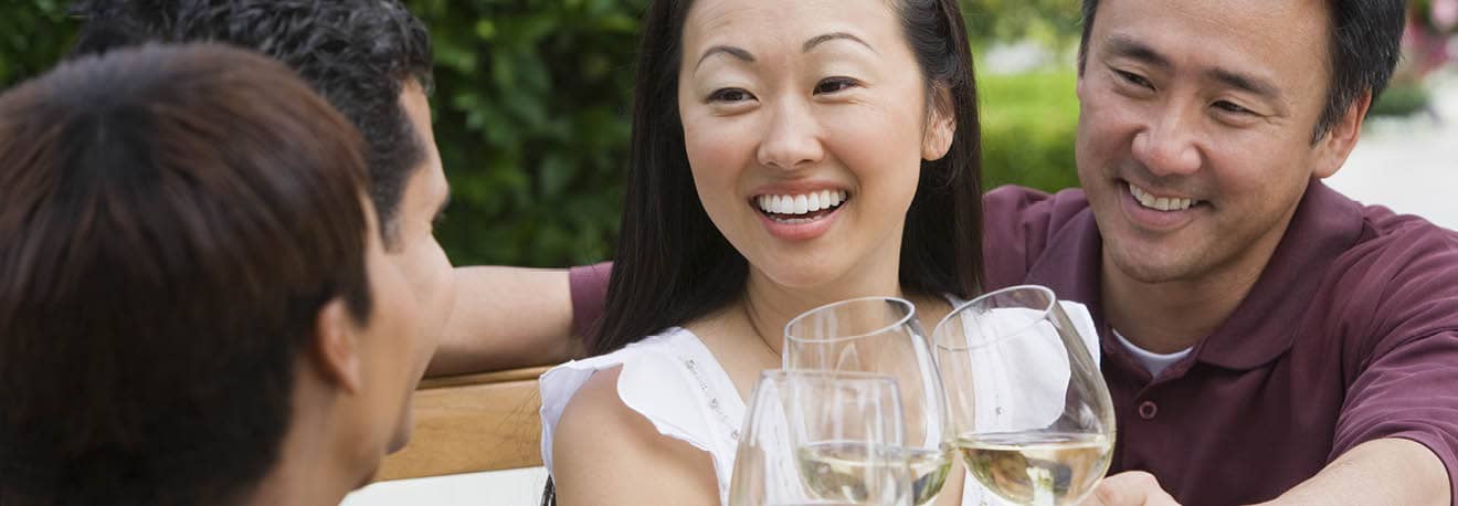 A group of friends gather to enjoy a glass of white wine.