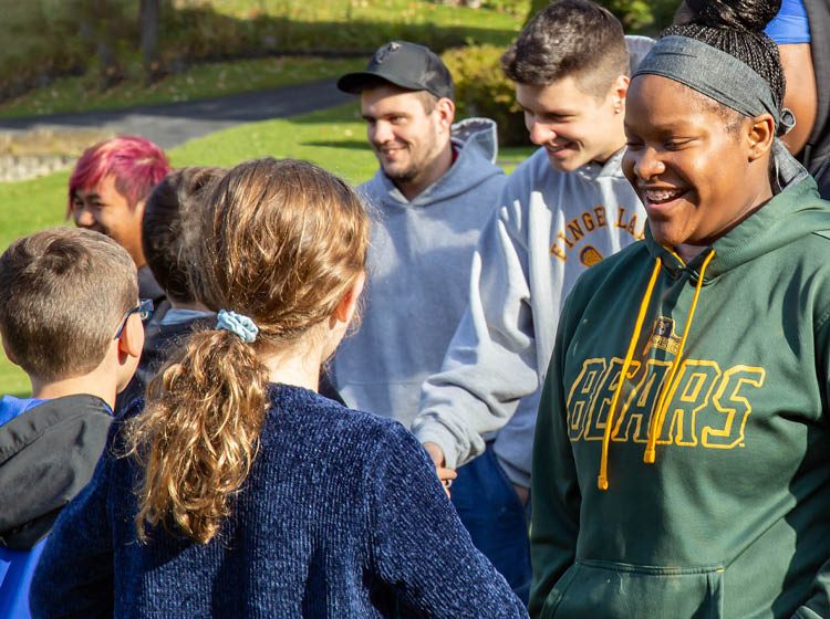 A group of educators and students learning together outside on a sunny summer day.